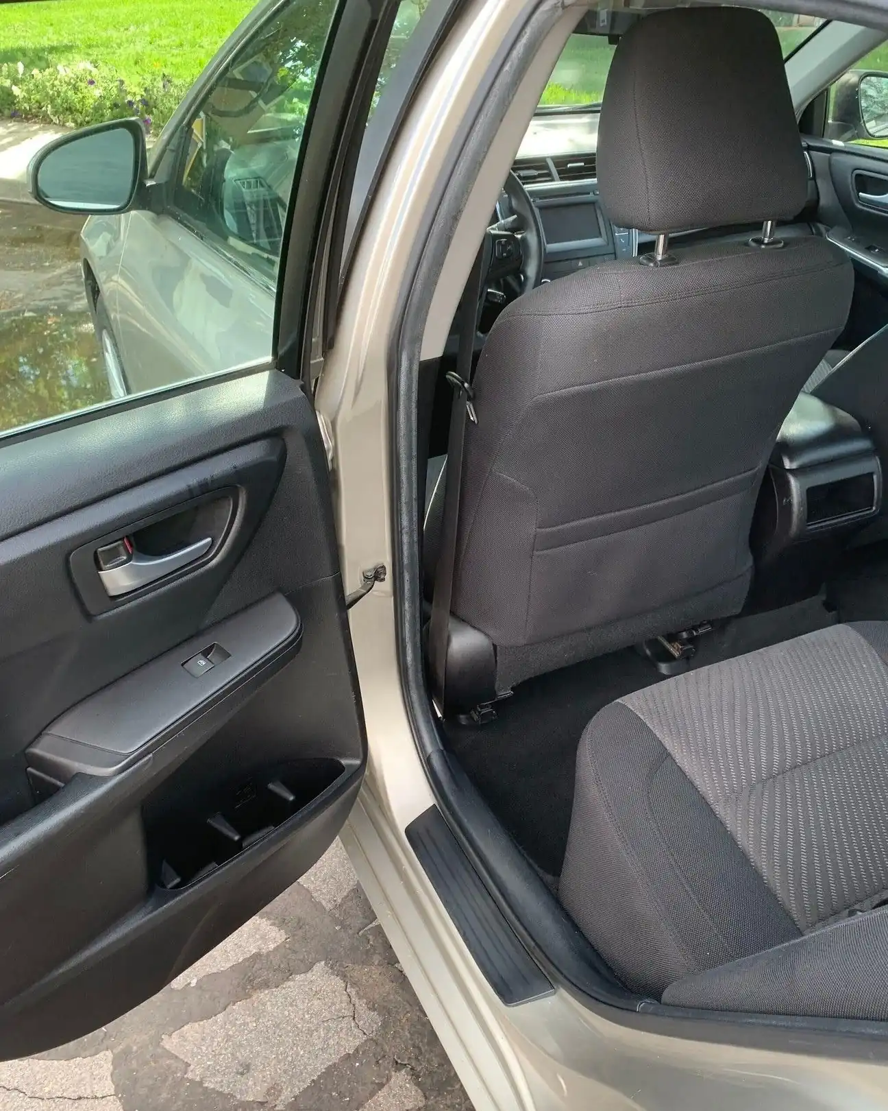 Quita olores auto: asientos de tela gris limpios con la puerta del auto abierta